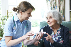 caregiver giving medicines to patient