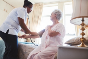 caregiver checking patient's blood pressure